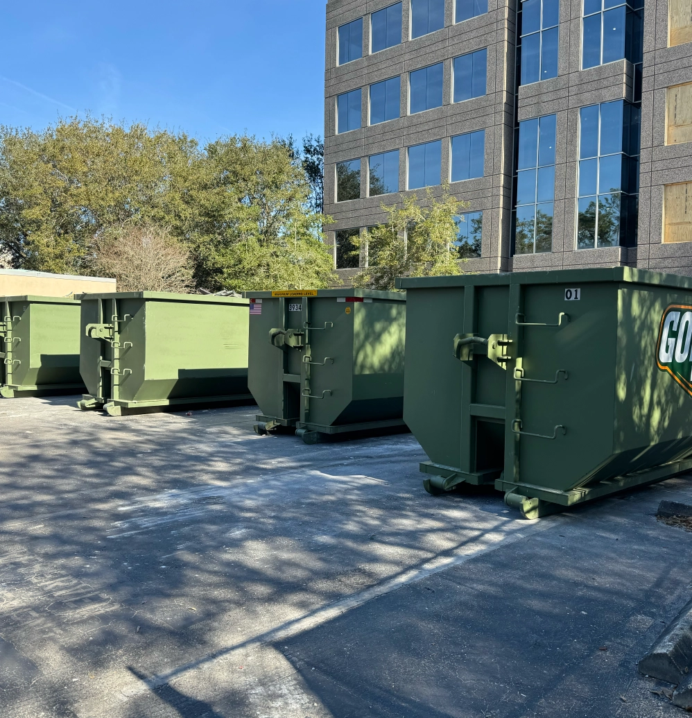 Multiple Gopher Waste roll-off dumpsters lined up at commercial warehouse